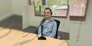 Nick, Support Coordinator at Allinto, speaking into a microphone as a podcast guest-speaker